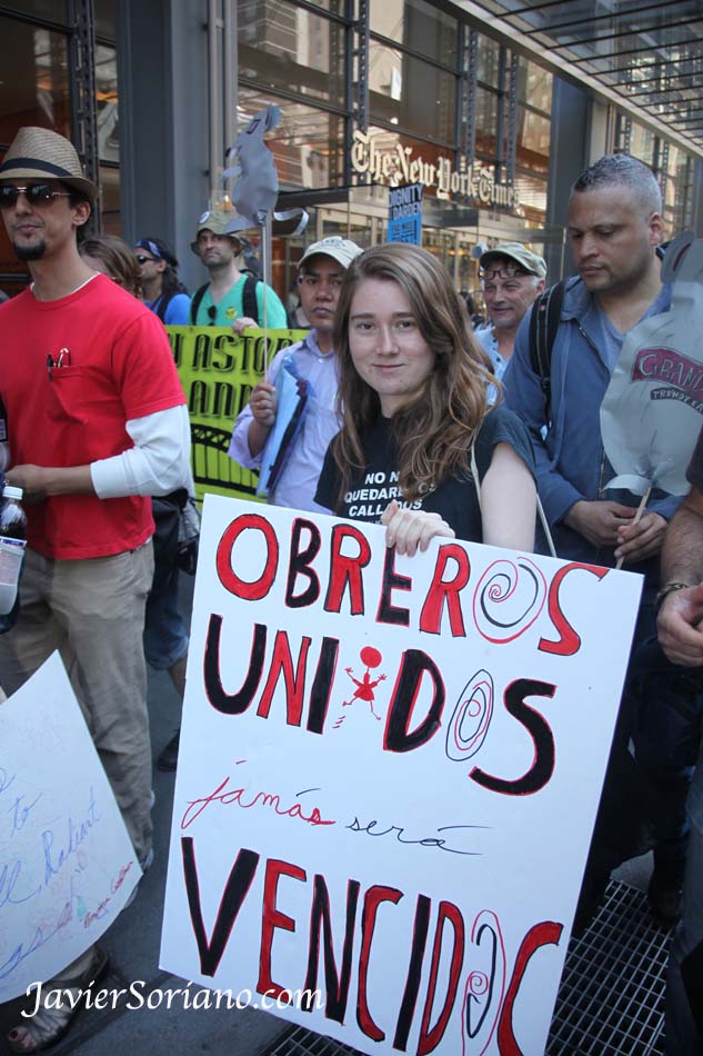 Wednesday, May 1, 2013. New York City - International Workers' Day.    Miércoles 1 de mayo de 2013. Ciudad de Nueva York. Día Internacional de los Trabajadores, también conocido como MAY DAY. Activistas caminando frente al New York Times en la calle 42 y 8 avenida. El anuncio de la chica dice: "Obreros unidos jamás serán vencidos".  Photo by Javier Soriano/www.JavierSoriano.com