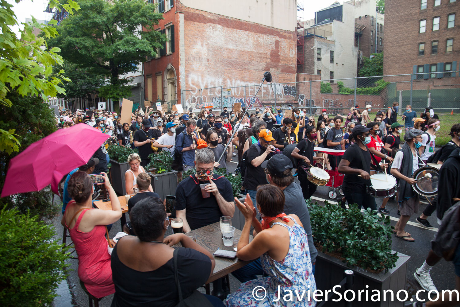 Monday, June 29, 2020. New York City – “Mass March to Defund the NYPD and Abolish the Police” organized by NYC-DSA. People gathered in Washington Square Park in Manhattan and marched to City Hall Park to join people at "Occupy City Hall". Protesters “demand that the City Council cut the NYPD police force and the NYPD budget in half and re-invest in community and social needs.” Protesters marching and some people having drinks. Photo by Javier Soriano/www.JavierSoriano.com