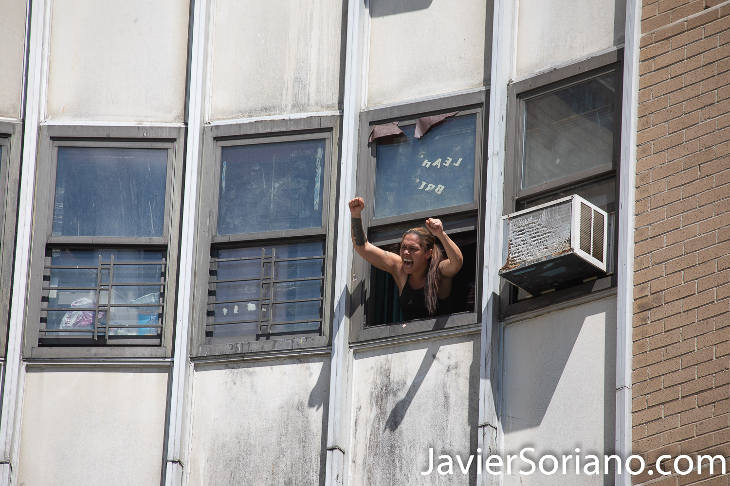 Friday, June 12, 2020. Brooklyn, New York City - Rally and march in Coney Island. Protestors said it was a "Peaceful demonstration for George Floyd, Breonna Taylor and the many other victims of police brutality." A woman in her apartment supporting protestors. Photo by Javier Soriano/www.JavierSoriano.com